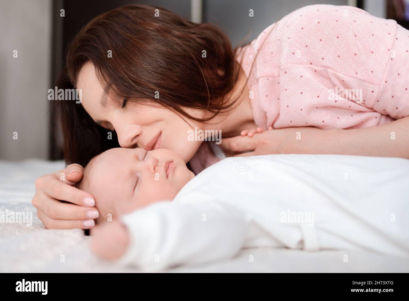 La jeune mère regarde avec amour sa fille de nouveau-né qui dormait
