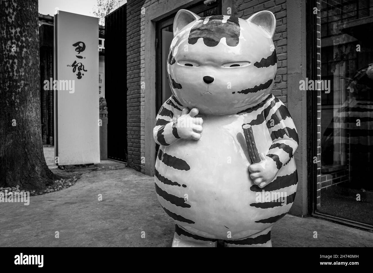 Sculpture d'un gros chat mangeant un concombre dans Dashanzi 798 Art zone.District de Chaoyang, Beijing, Chine.Noir et blanc. Banque D'Images