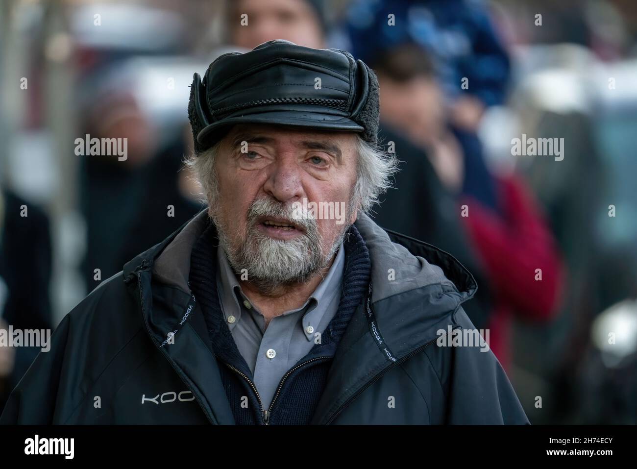 18-11-2021 Riga, Lettonie ancienne génération.Le portrait d'un homme barbu positif et âgé en chapeau est debout à l'extérieur et regarde l'appareil photo Banque D'Images