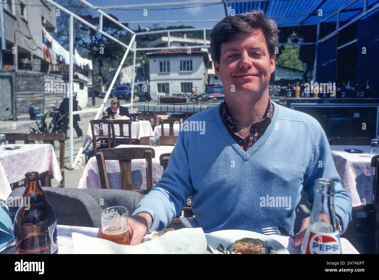 1981, Jeune Homme en vacances en profitant d'un restaurant en plein air Banque D'Images