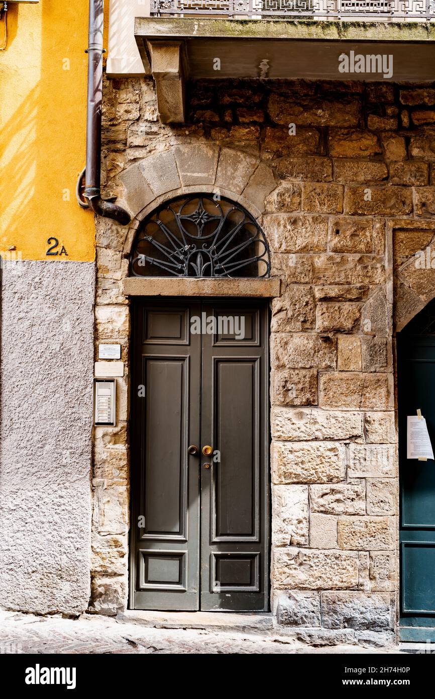 Porte étroite dans un vieux bâtiment en briques sous le balcon.Bergame, Italie Banque D'Images