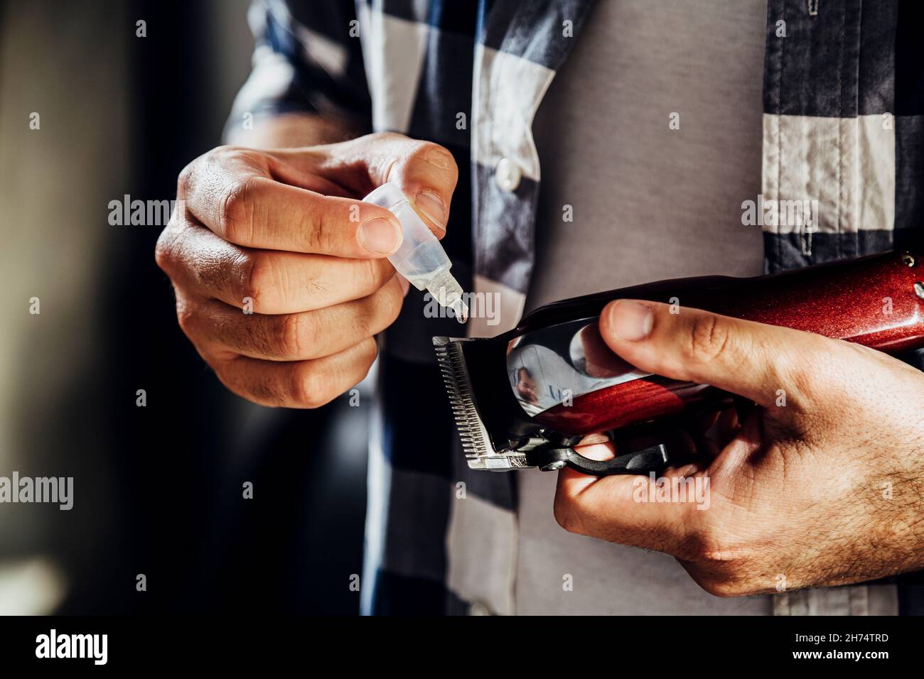 Barber de l'huile dans sa tondeuse à cheveux Banque D'Images