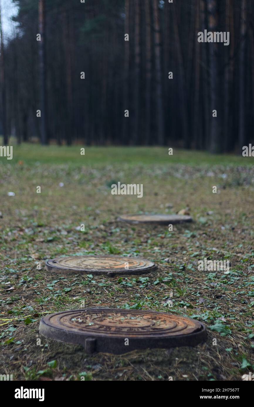 Capuchon de trou d'homme rouillé grince couvercle de trou d'homme avec  chemin de coupure porte souterraine sur fond de forêt herbe Photo Stock -  Alamy