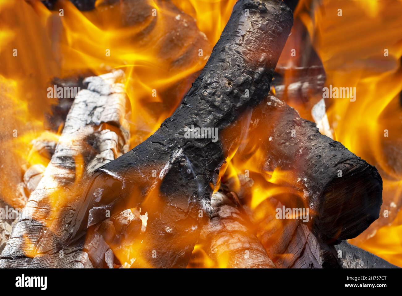Arrière-plan sous forme de flammes et de bois de chauffage brûlant dans une cheminée à la maison la veille de Noël. Banque D'Images