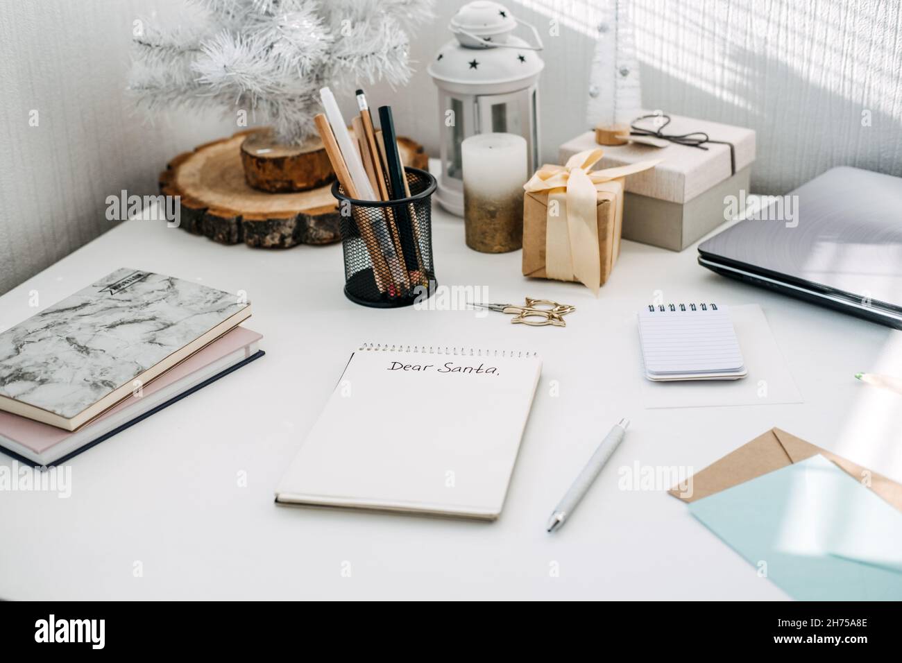 Liste de souhaits, lettres modernes au Père Noël des enfants et des adultes.Texte manuscrit cher Père Noël dans le bloc-notes ouvert sur la table.Papier et crayon prêts à l'emploi Banque D'Images