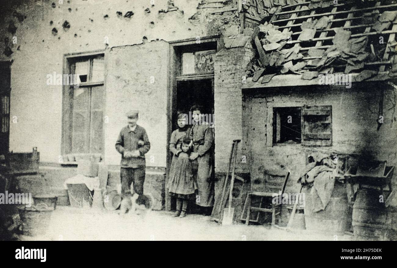 Une vue historique de la famille française se tenant à l'extérieur de leur maison endommagée sur la rue Becourt à Albert, somme, France, pendant la première Guerre mondiale. Banque D'Images