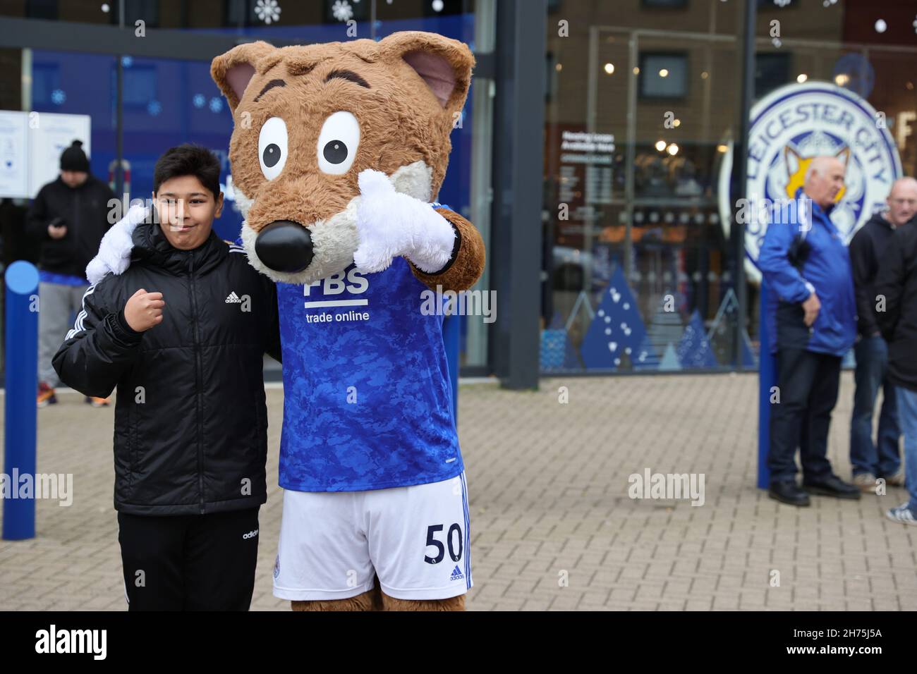 LEICESTER, ANGLETERRE - NOVEMBRE 20 : Filber Fox, la mascotte de la ville de Leicester, pose pour une photo avec un fan lors du match de la Premier League entre Leicester City et Chelsea au King Power Stadium le 20 novembre 2021 à Leicester, en Angleterre.(Photo de James HolyOak/MB Media/Getty Images) Banque D'Images