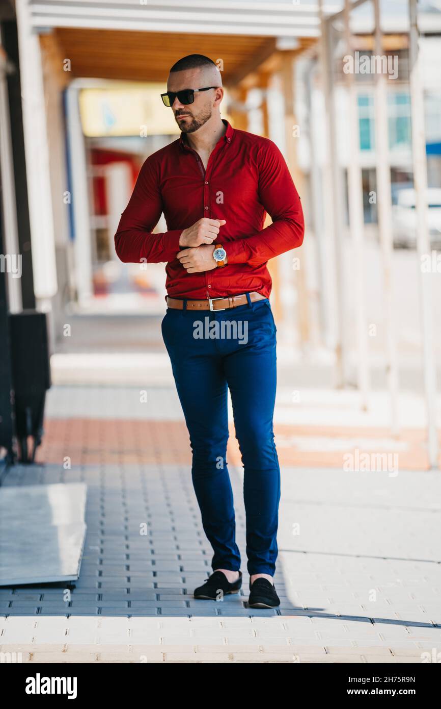 Photo verticale d'un jeune homme dans une chemise rouge avec un look  d'affaires avec des lunettes de soleil Photo Stock - Alamy