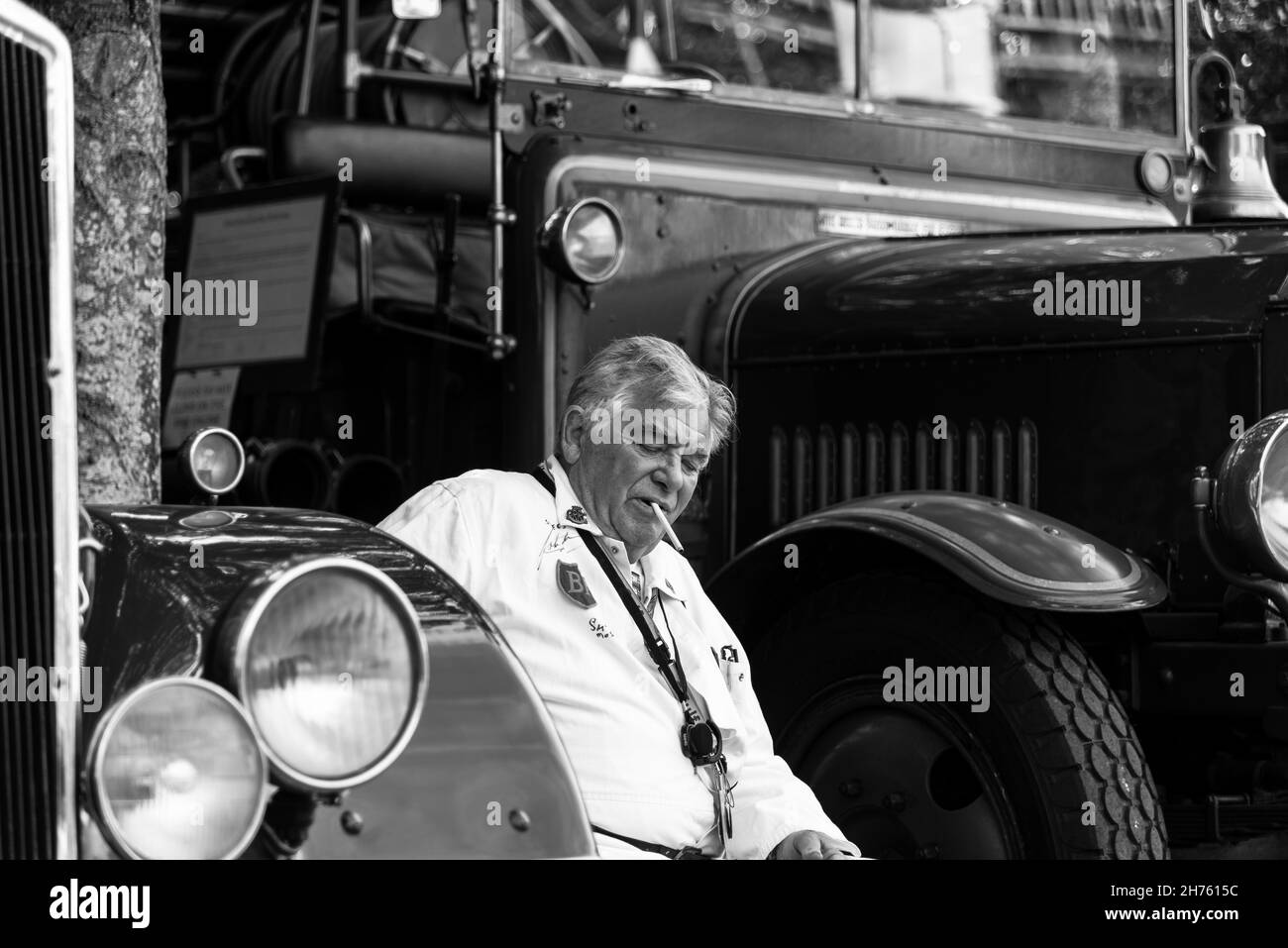 Un vieil homme en combinaison fume Banque D'Images