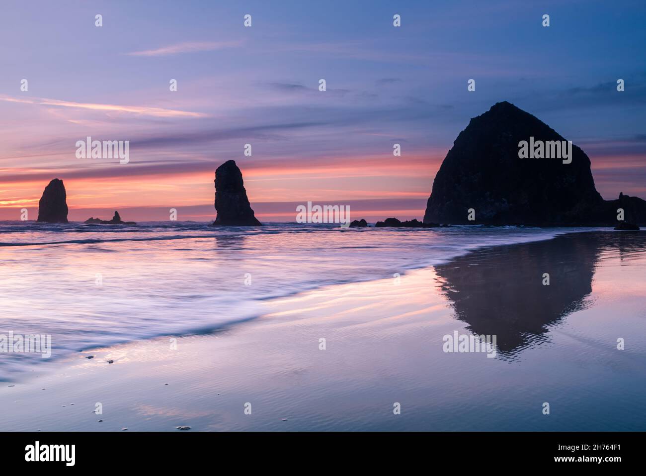 Vagues devant Cannon Beach haystack au coucher du soleil Banque D'Images