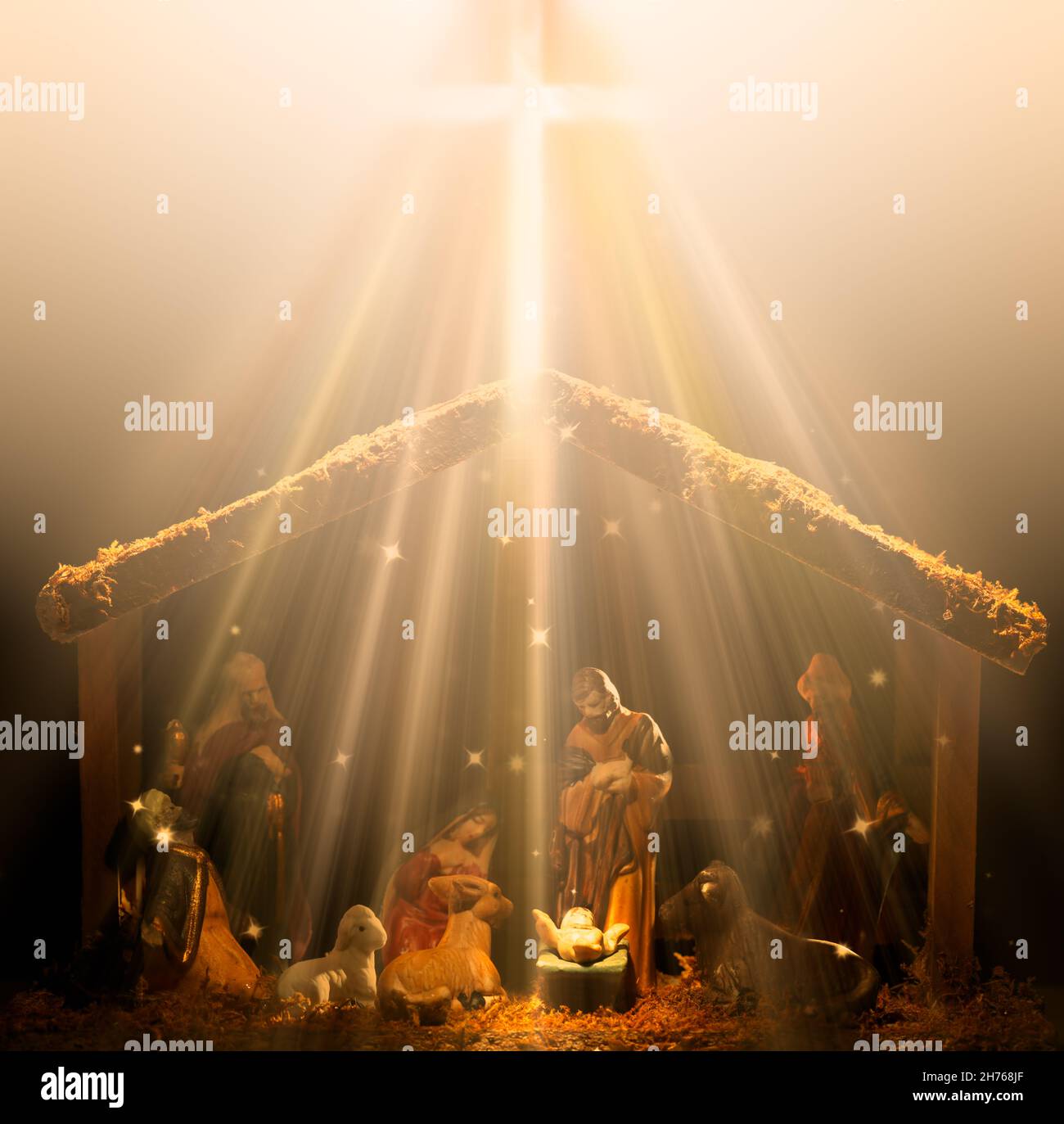 Scène de la nativité chrétienne qui brille dans les rayons de lumière célestes avec le bébé Jésus qui brille au centre. Banque D'Images
