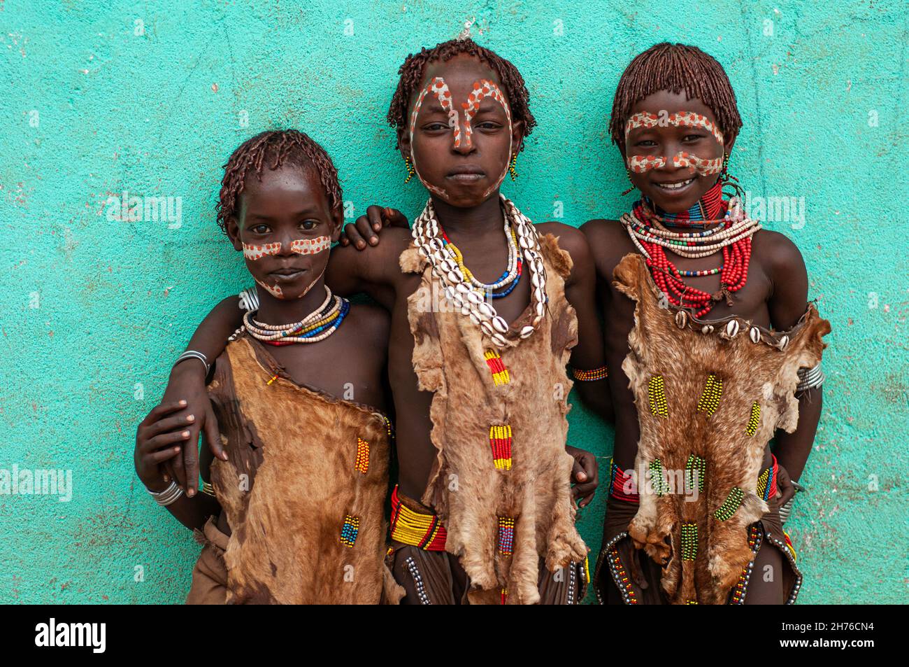 Trois jeunes filles de la tribu Hamar avec des visages peints, des perles et des peaux d'animaux typiques de leur tribu Banque D'Images