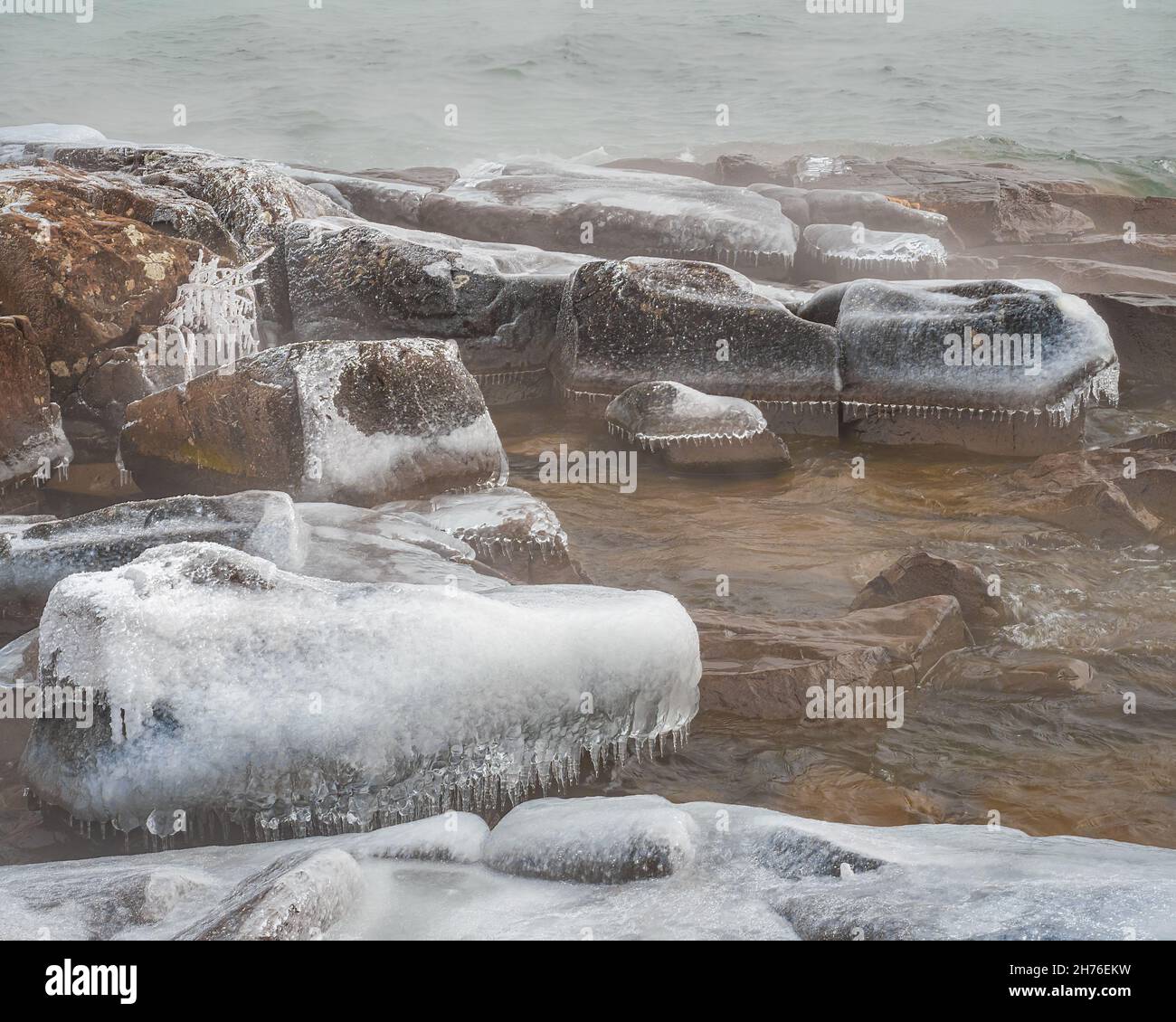 En hiver, les vagues de gel forment des glaçons miniatures sur les rochers le long du lac supérieur Banque D'Images