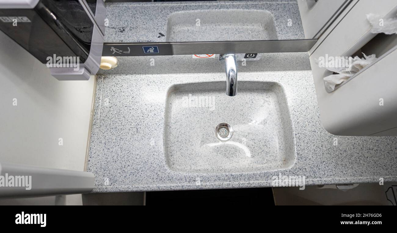 Lavabo en plastique dans la salle de bains de la cabine de toilette du porte-avions Boeing 737-800.Confort public et toilettes à bord d'un avion. Banque D'Images