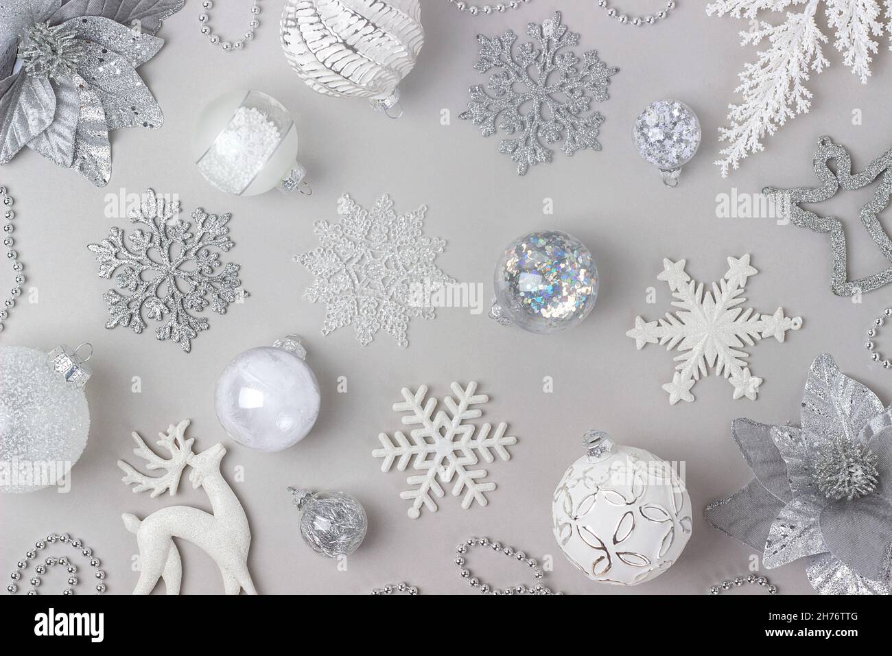 Motif des fêtes fait argent et blanc brillant décorations de noël sur fond gris.Concept joyeux Noël, Noël et nouvel an.Vue de dessus, Flat lay. Banque D'Images