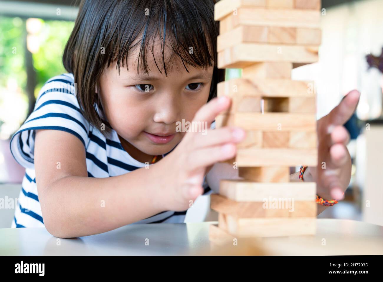 Petit enfant mignon joue Jenga jeu de blocs de bois.Avoir le plaisir et  l'apprentissage de la créativité concentrée sur les yeux déterminés Photo  Stock - Alamy