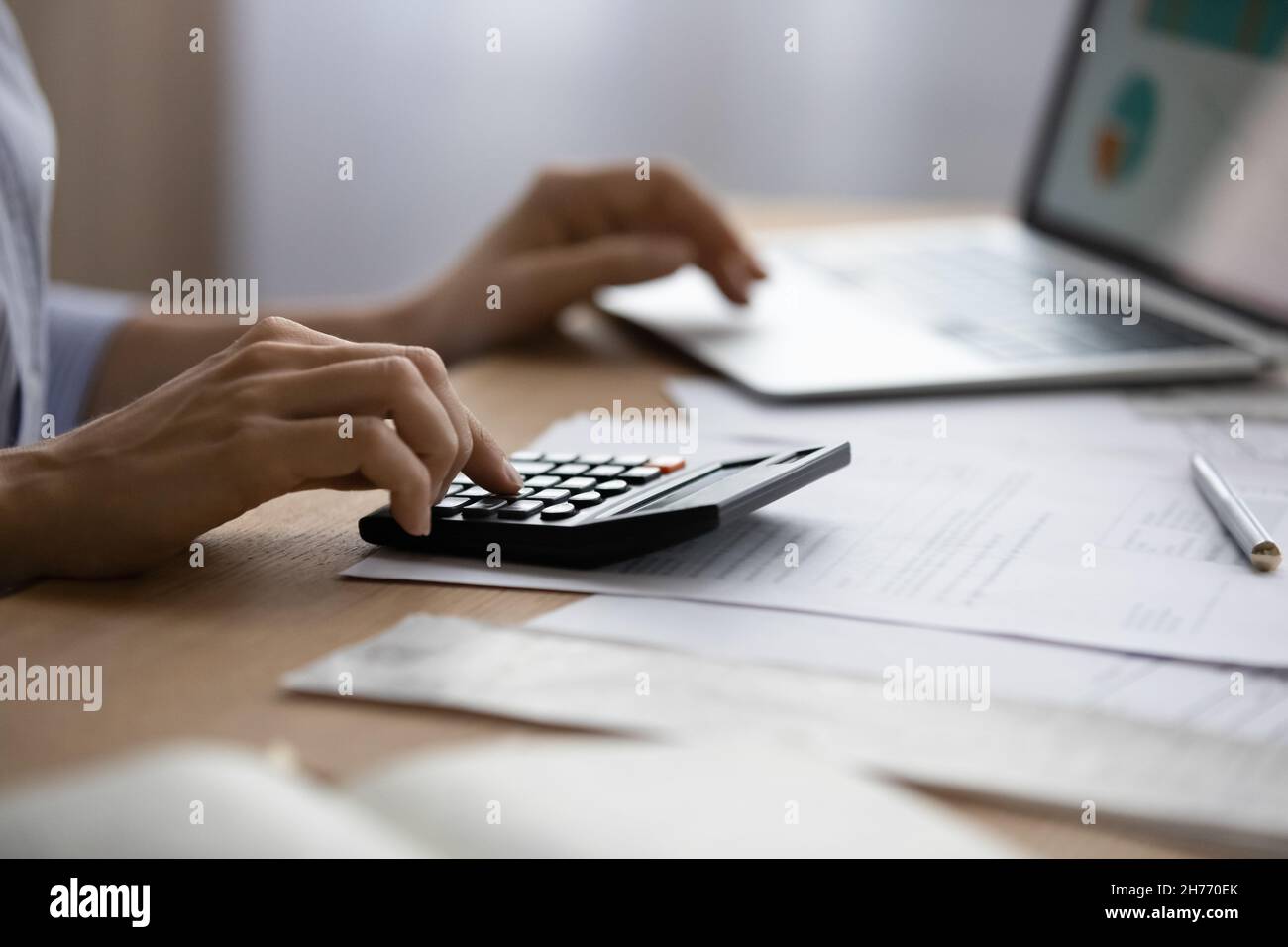 Gros plan femme utilisant un ordinateur portable et une calculatrice Banque D'Images