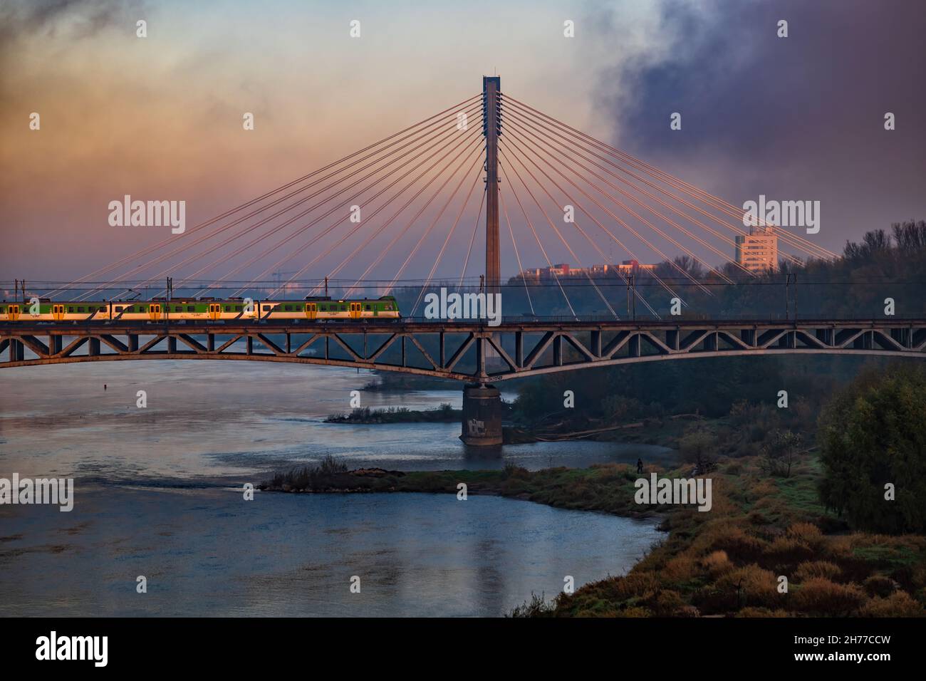 Aube par la Vistule (Wisła) dans la ville de Varsovie en Pologne, tôt le matin avec le brouillard passant et train sur le pont ferroviaire Średnicowy avec Swiętokrzysk Banque D'Images