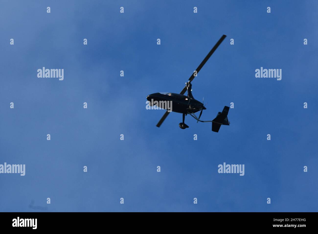 Un gyrocoptère, un gyrocoptère, un autogyro, volant haut au-dessus de l'Angleterre rurale lors d'une journée automnale Banque D'Images