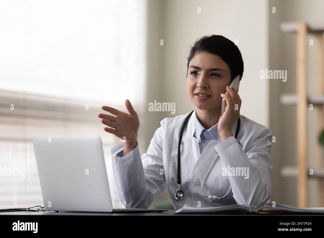 Femme indienne souriante médecin parlant au téléphone, consultant le patient Banque D'Images