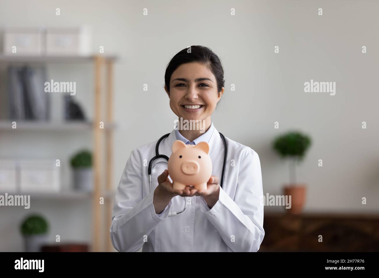 Portrait de la tête souriant femme indienne médecin tenant une banque de porc Banque D'Images