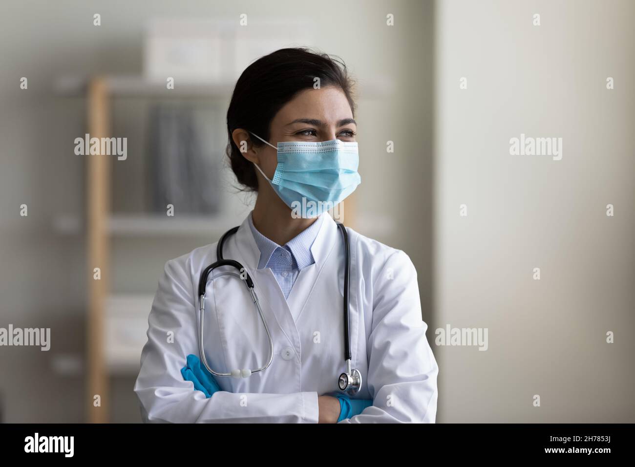 Femme indienne heureuse médecin dans le masque médical rêvant, visualisant Banque D'Images