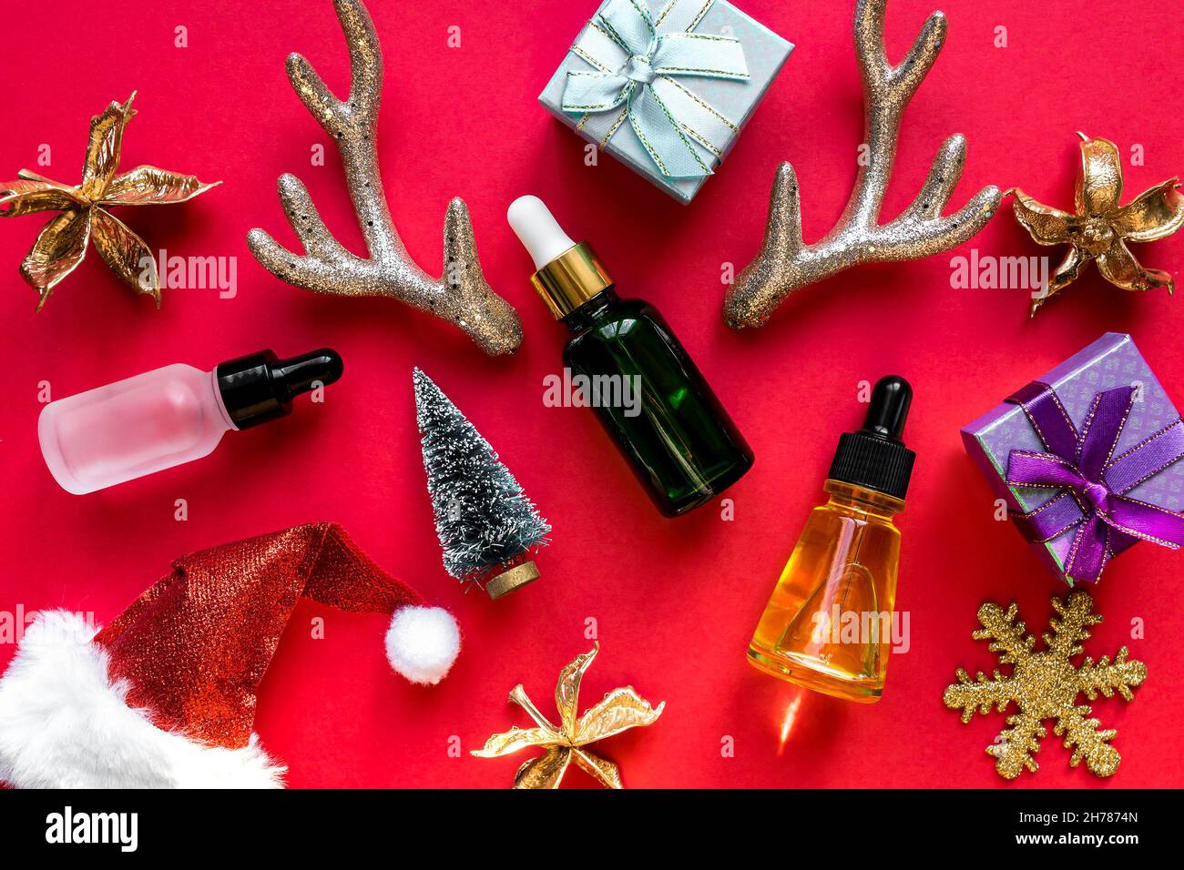 Produits de beauté pour les soins de la peau sur fond rouge de noël.Huile  pour le visage dans des bouteilles en verre avec décoration de noël.Publicité  de fête Photo Stock - Alamy