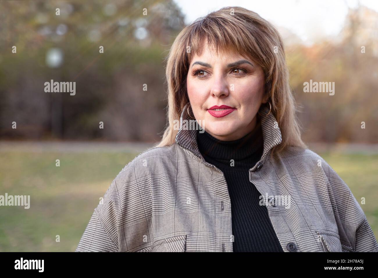 Une belle femme mûre aux courbes regarde sur le côté.Portrait féminin d'une personne d'âge moyen à l'extérieur Banque D'Images