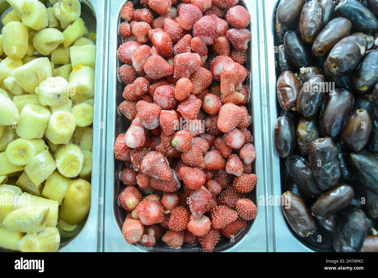 Présentation de fruits surgelés dans un magasin de yaourts glacés (de gauche à droite) Banana, fraises et dattes Banque D'Images