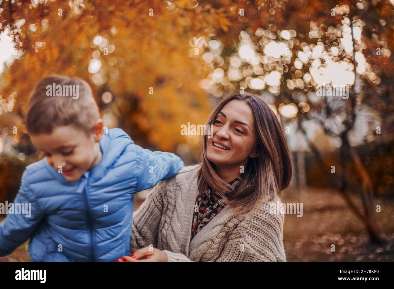 Jeune famille heureuse aimant mère et petit garçon fils marchant à l'extérieur le jour de l'automne, maman et enfant jouant à des jeux actifs dans le parc et s'amusant sur frais Banque D'Images