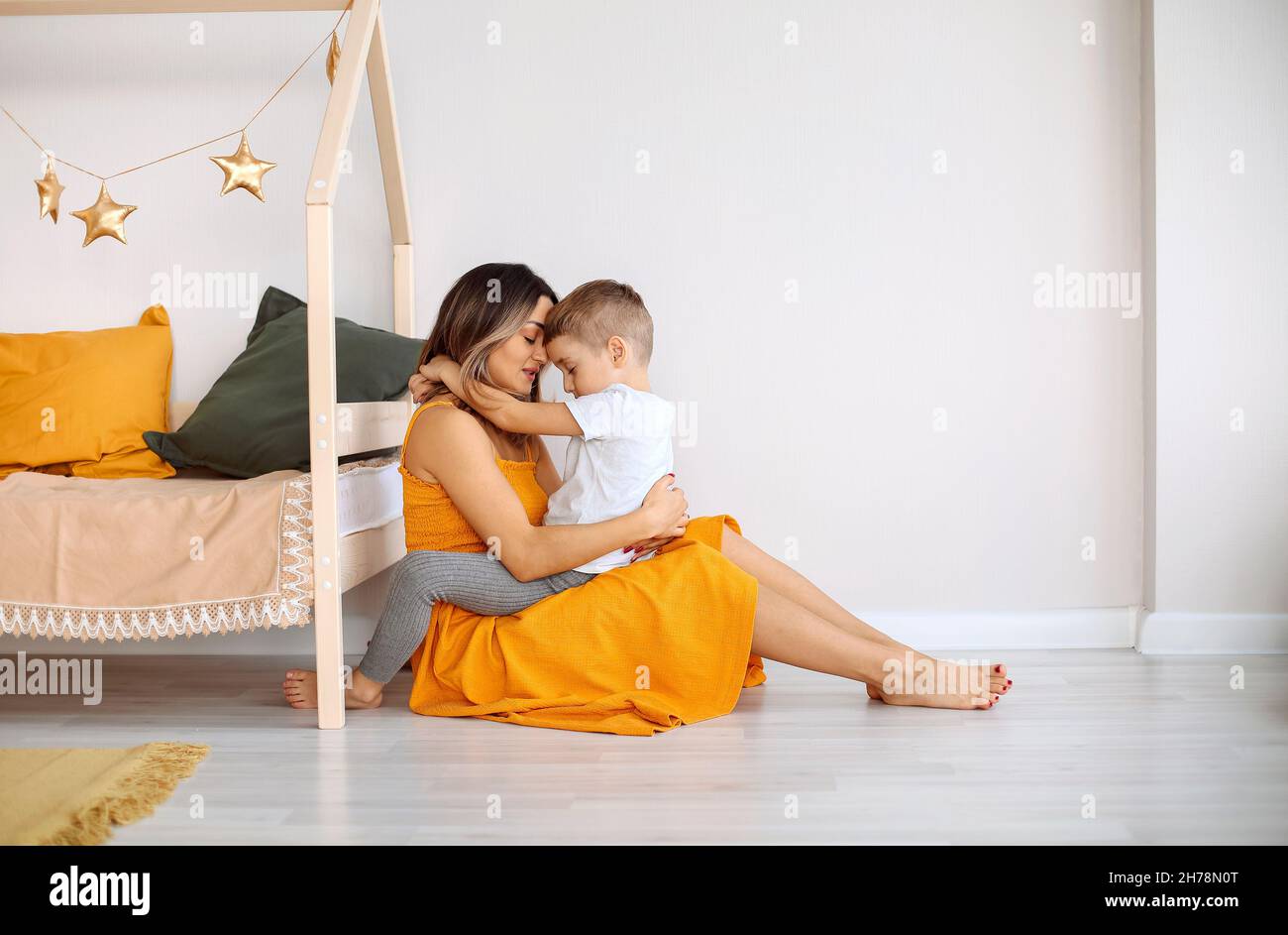 Jeune famille heureuse mère aimante et son enfant fils s'amuser ensemble à la maison, jouer et rire.Enfant souriant embrassant sa mère, heureux de Banque D'Images