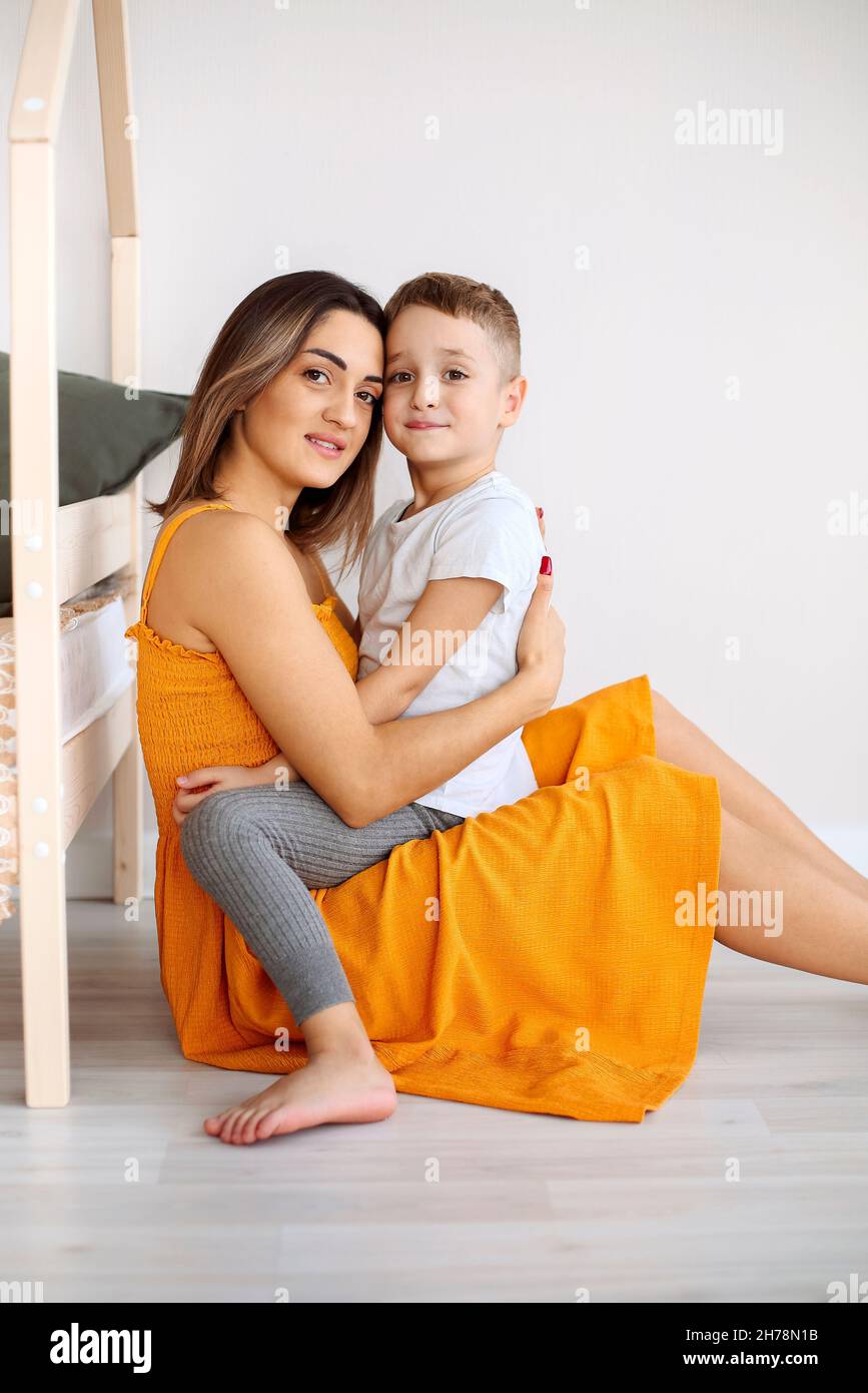 Jeune famille heureuse mère aimante et son enfant fils s'amuser ensemble à la maison, jouer et rire.Enfant souriant embrassant sa mère, heureux de Banque D'Images