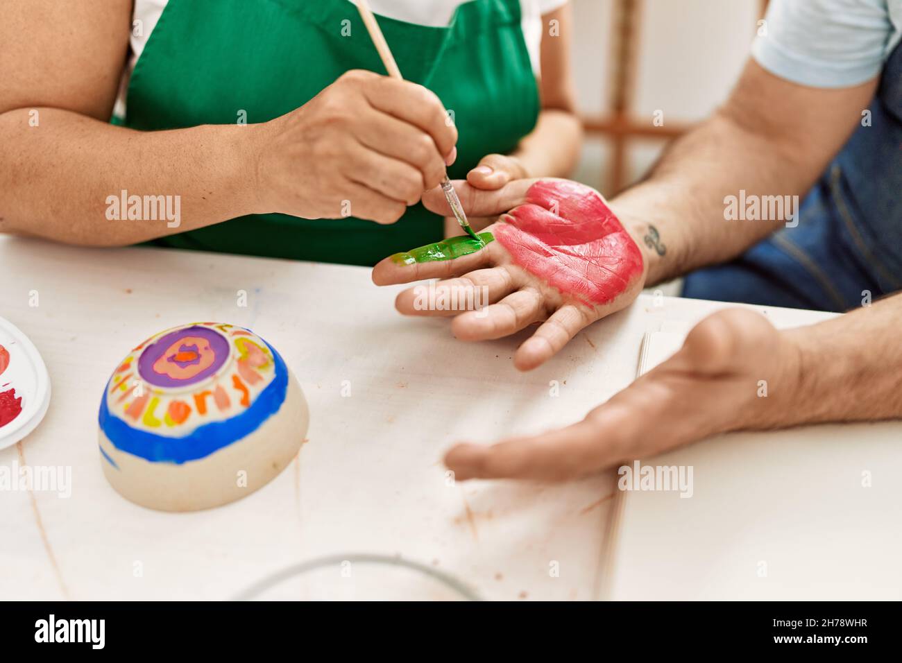 Couple d'artistes peignant des mains de palmier au studio d'art. Banque D'Images