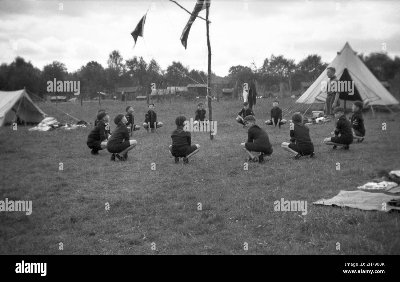 1938, historique, camp scout de Cub, le Grand Howl, Felbridge,Surrey, Angleterre, Royaume-Uni.À l'extérieur, dans un champ, un groupe de scouts de cub s'agenouillent dans un cercle avec leur maître scout lors d'une cérémonie qui aurait été inspirée par les rencontres de meunerie dans le livre Jungle Book, un célèbre roman de Rudyard Kipling,Où les animaux commencent par encercler leur chef Akela et howing.Le Grand Howl rassemble tout le monde et les aide à se concentrer.Robert Baden-Powel, le fondateur des scouts, a mis en place en 1916 un programme pour les garçons âgés de 8-10 ans à rejoindre, en les nommant 'Wolf Cubs'. Banque D'Images