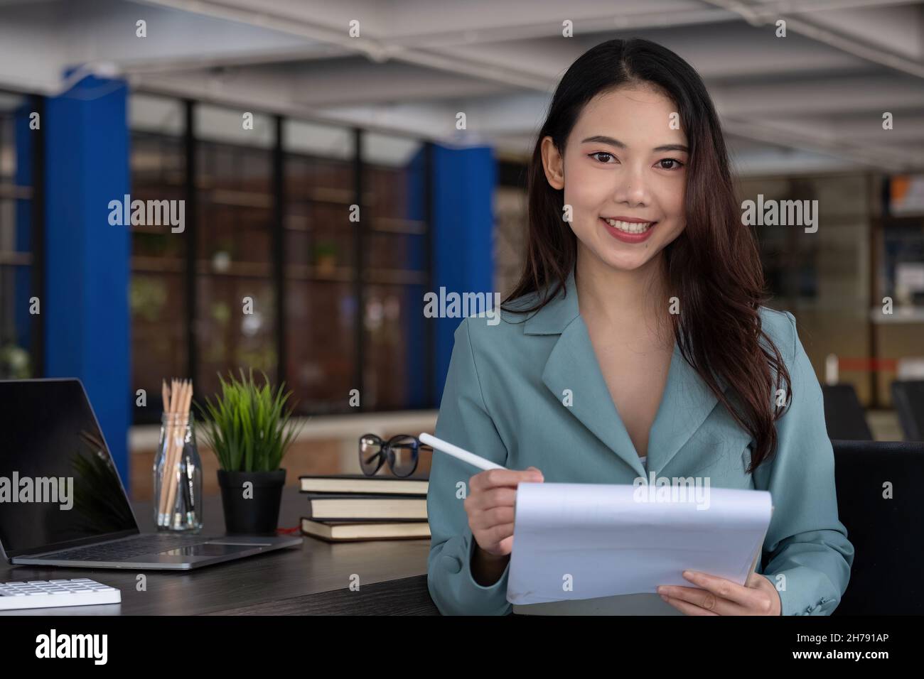 Portrait de la belle femme d'affaires asiatique se tenir et regarder l'appareil photo au bureau Banque D'Images