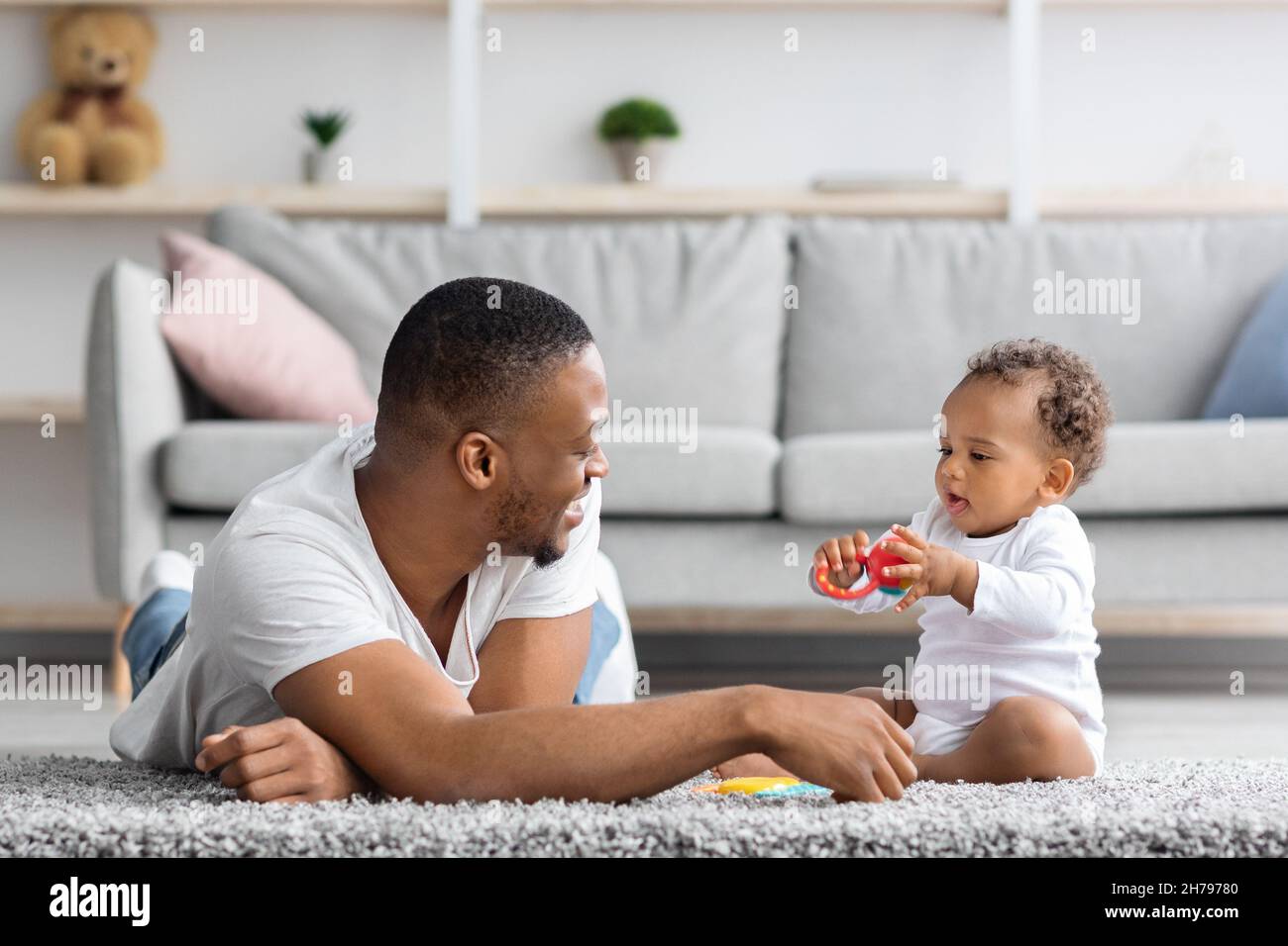 Congé parental partagé.Jeune Père noir jouant avec bébé à la maison, heureux Africain américain homme passer du temps avec son adorable bébé enfant à l'intérieur Banque D'Images