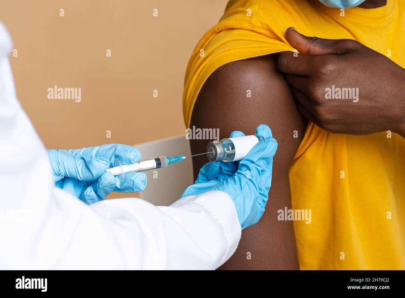 Médecin en Blue gants prendre une dose de vaccin à partir d'un flacon avec seringue Banque D'Images
