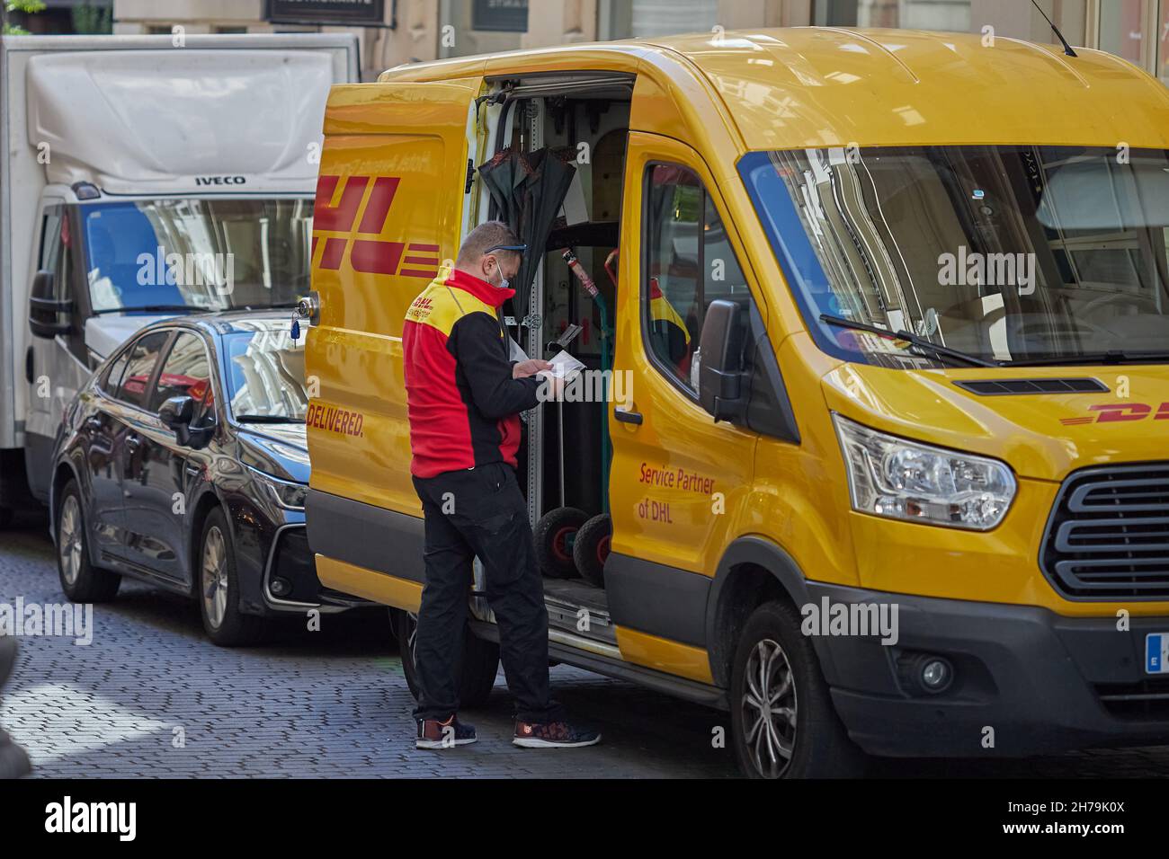 DHL préposé à la livraison de colis attendant devant la camionnette de livraison (Madrid, Espagne). Banque D'Images