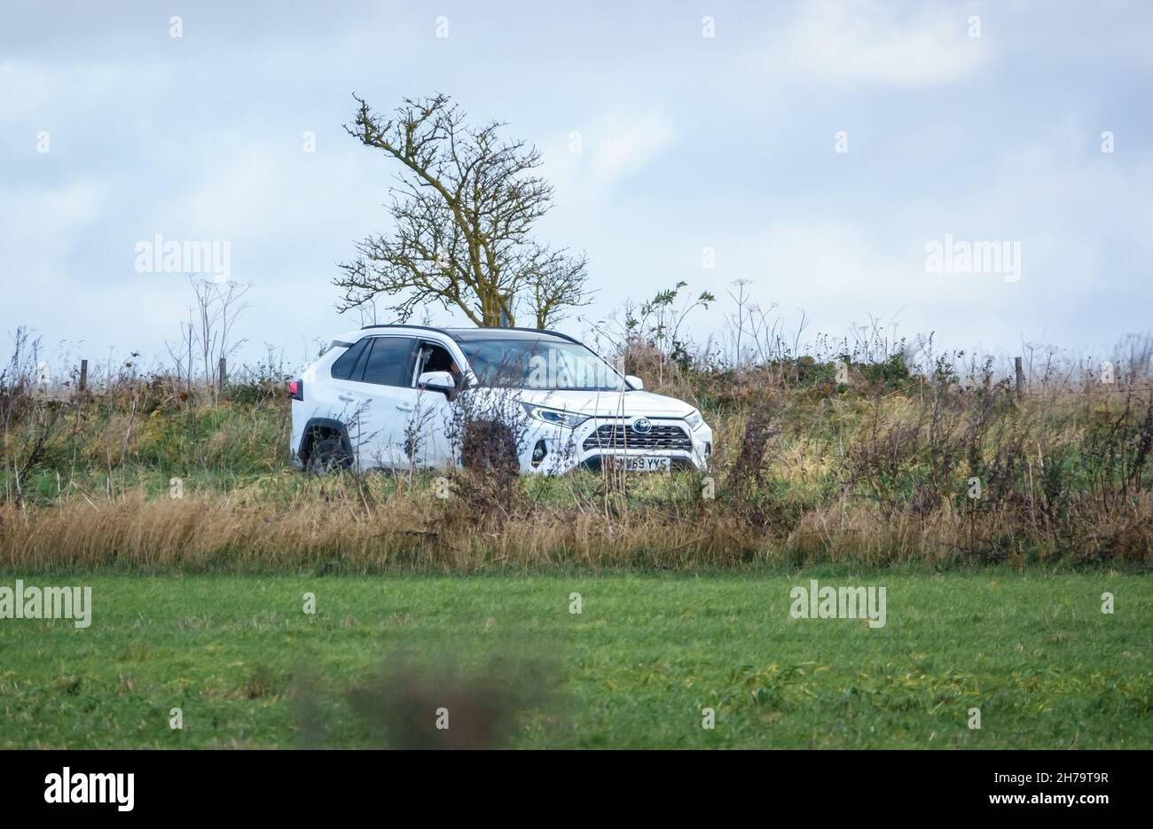 Une Toyota RAV4 hybride blanche à auto-charge (véhicule d'activité de loisir) qui longe une route de campagne dans le Wiltshire au Royaume-Uni Banque D'Images