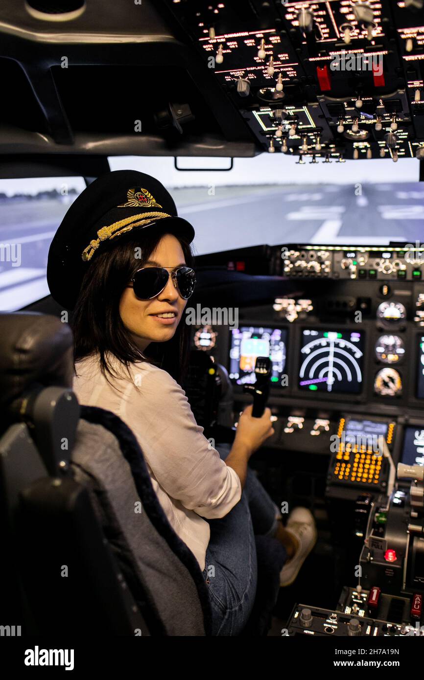 Femme pilote dans le cockpit d'avion.Pilote portant des lunettes de soleil et un chapeau Banque D'Images Femme pilote dans le cockpit d'avion.Pilote portant des lunettes de soleil et un chapeau Banque D'Images