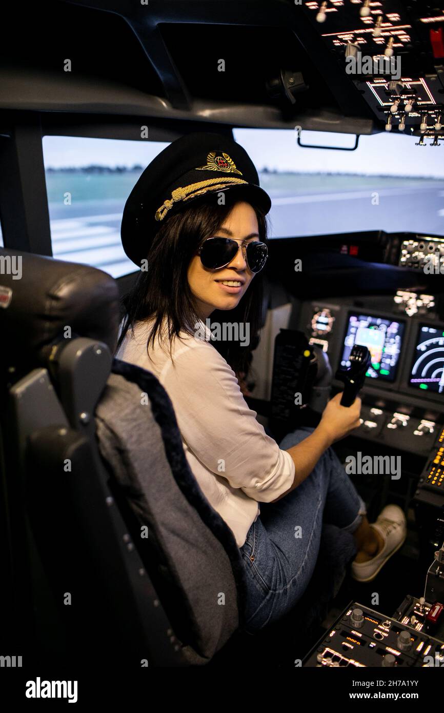 Femme pilote dans le cockpit d'avion.Pilote portant des lunettes de soleil et un chapeau Banque D'Images Femme pilote dans le cockpit d'avion.Pilote portant des lunettes de soleil et un chapeau Banque D'Images
