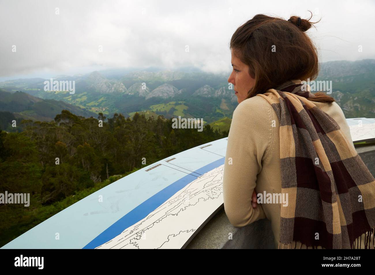 Jeune femme regardant le paysage panoramique vue paysage depuis Mirador de El Fitu vue dans un ciel nuageux (Caravia, Asturias, Espagne) Banque D'Images