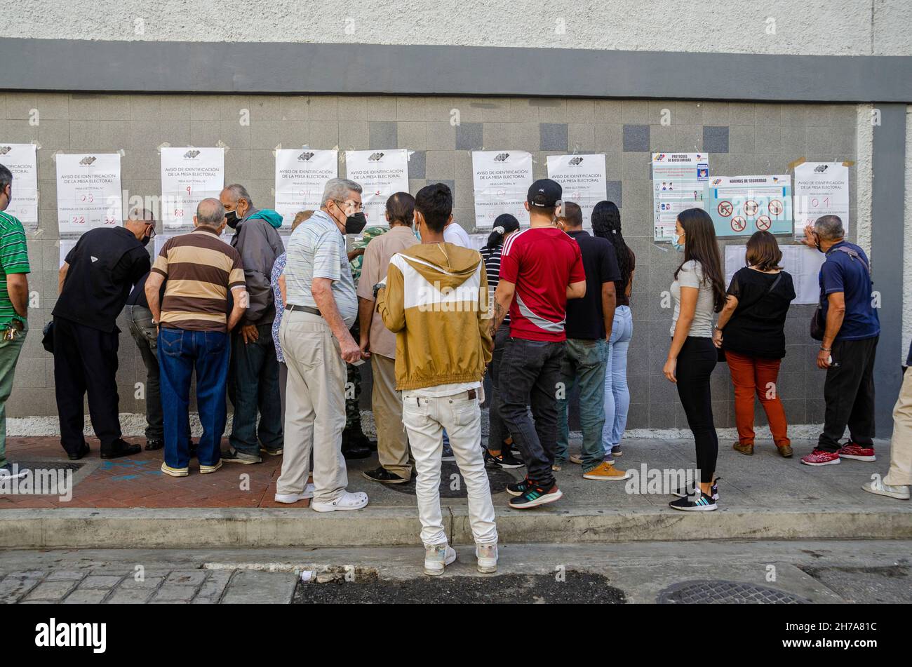 Les gens attendent à l'extérieur d'une école comme centre de vote à Caracas.Les Vénézuéliens votent dimanche 21 novembre lors des élections nationales et municipales, où 23 gouvernent Banque D'Images