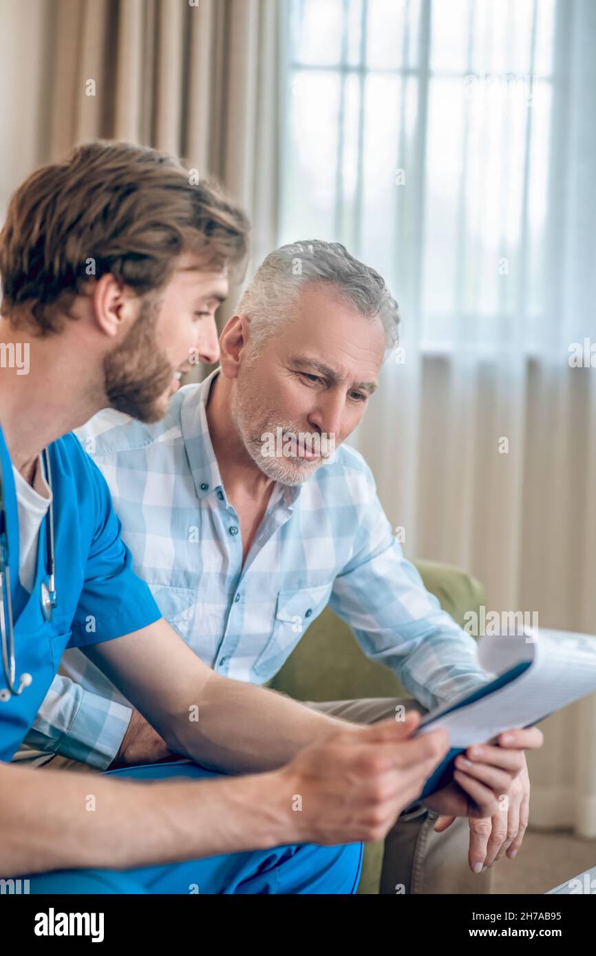 Médecin content montrant les résultats de l'examen médical à un homme mature Banque D'Images