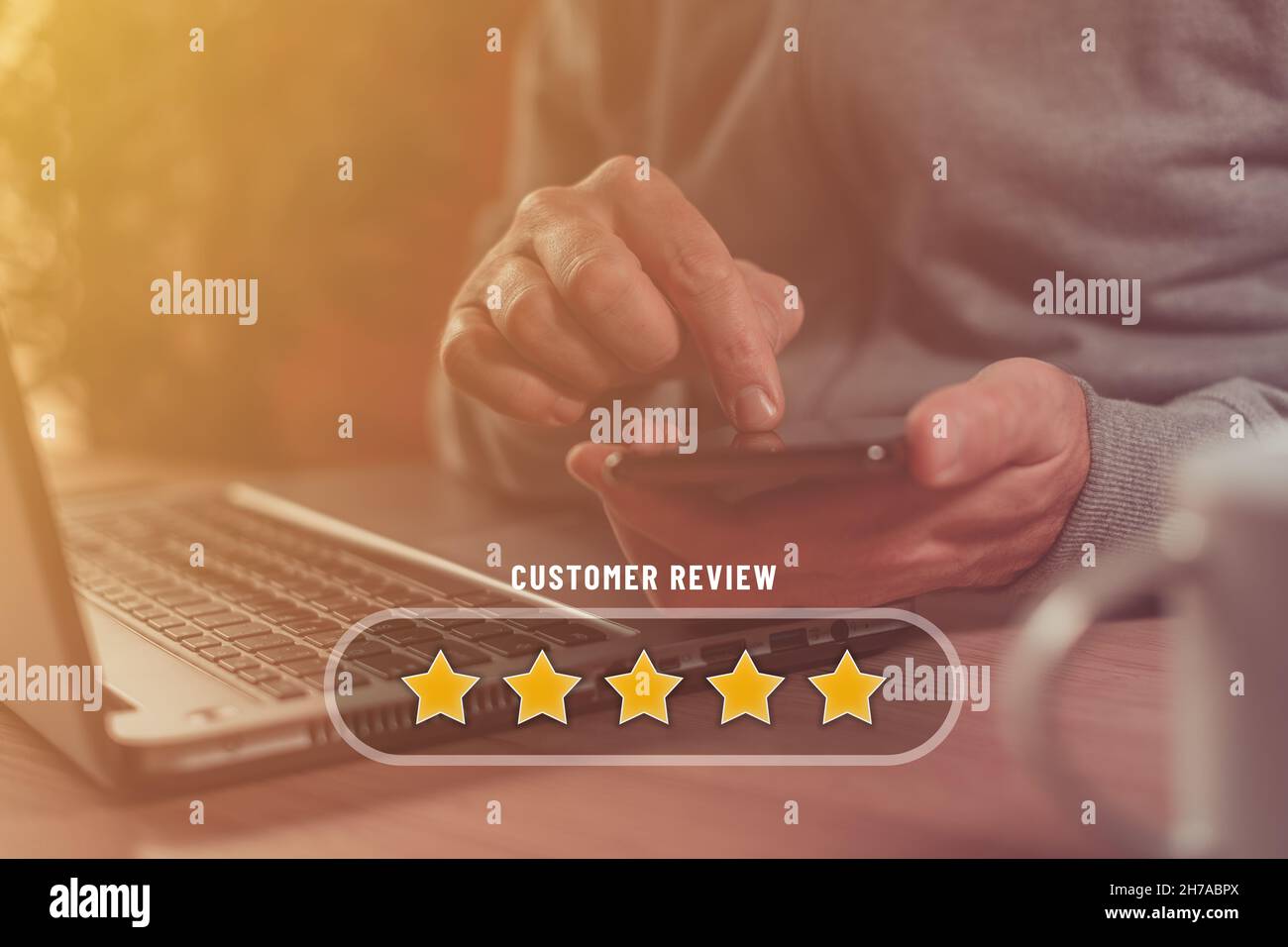 Avis des clients et concept d'évaluation cinq étoiles, homme utilisant un smartphone et un ordinateur portable pour le tarif de service en ligne, attention sélective Banque D'Images Avis des clients et concept d'évaluation cinq étoiles, homme utilisant un smartphone et un ordinateur portable pour le tarif de service en ligne, attention sélective Banque D'Images