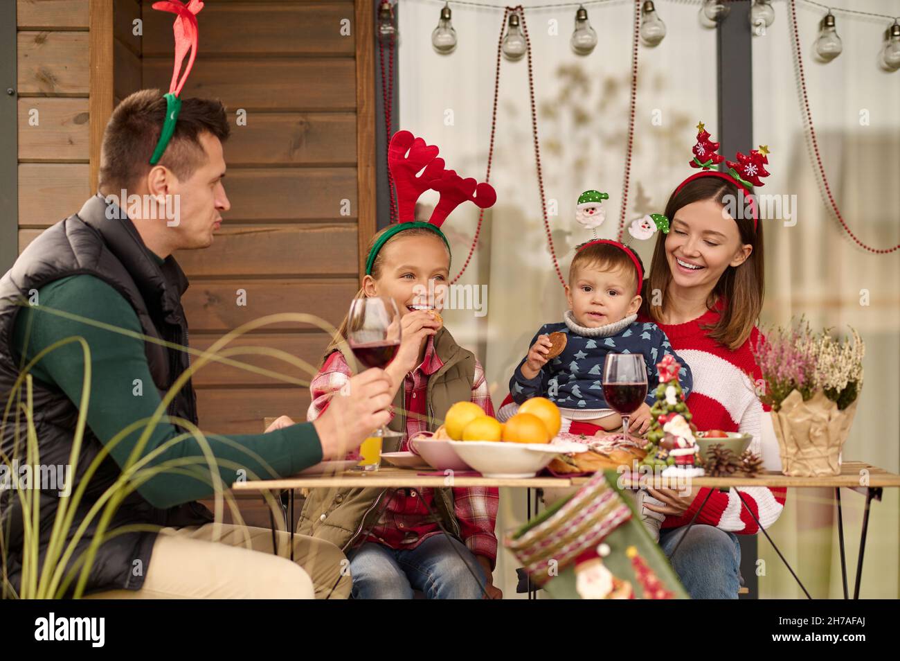 Une famille heureuse assise à la table et célébrant noël Banque D'Images