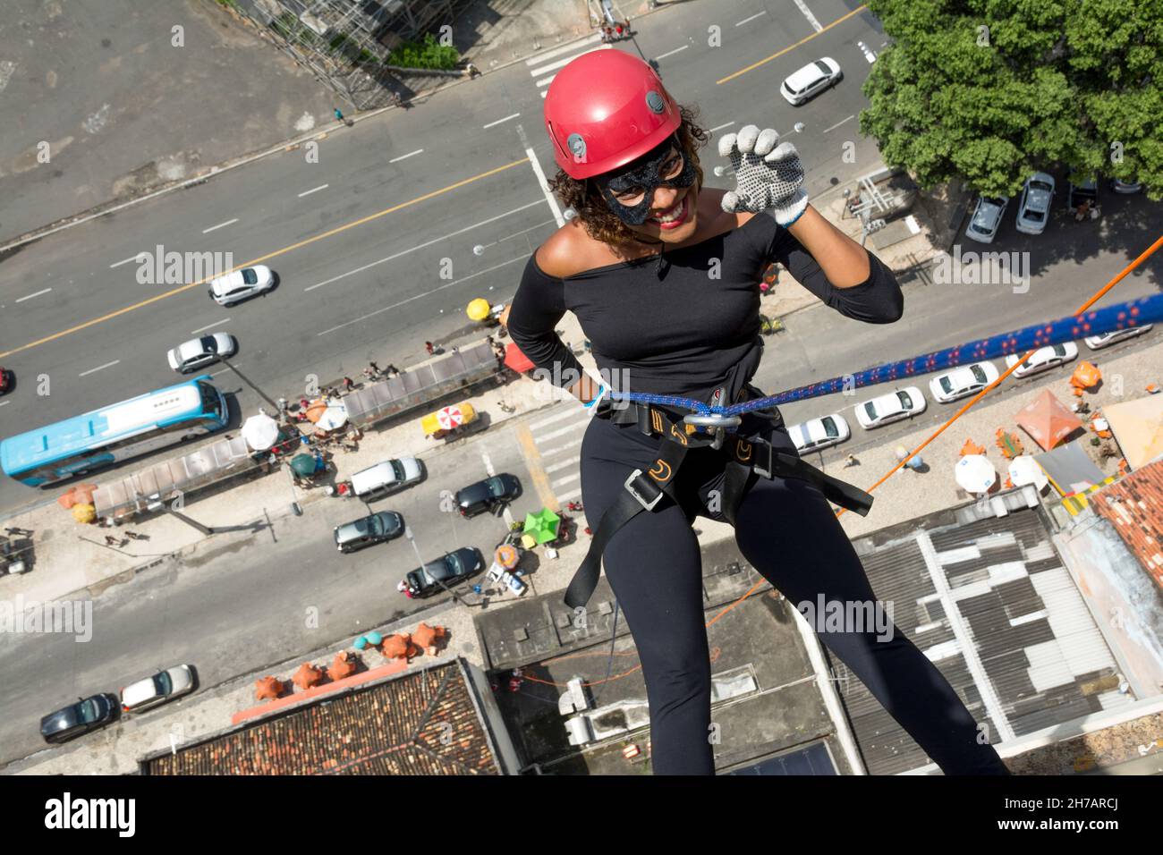 Une femme portant un costume de héros avec un casque de protection marchant dans un grand bâtiment de Rappel.Salvador Bahia Brésil. Banque D'Images