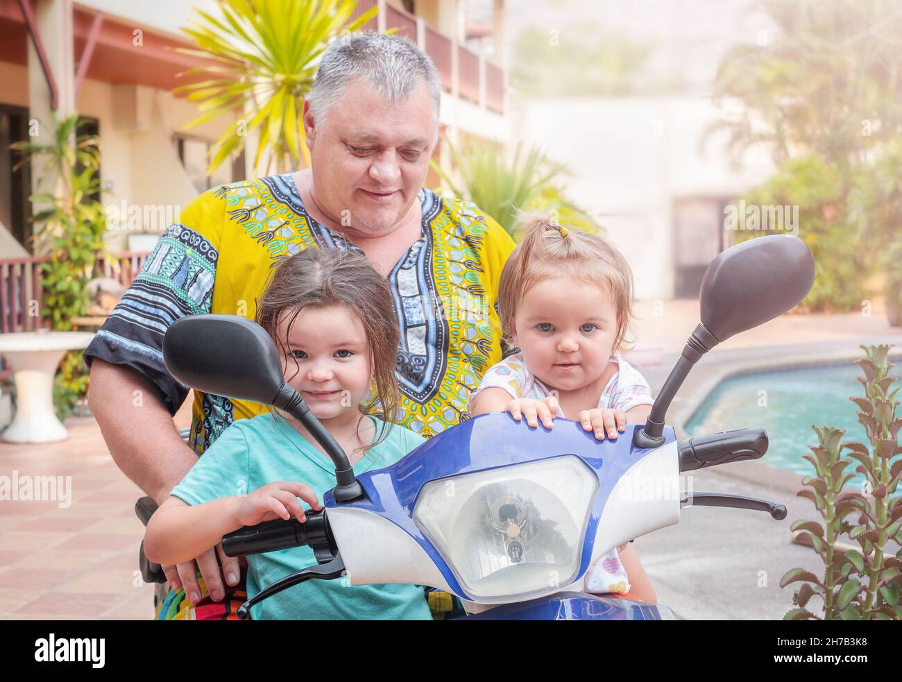 Grand-père avec petits-enfants sur un portrait de moto électrique Banque D'Images