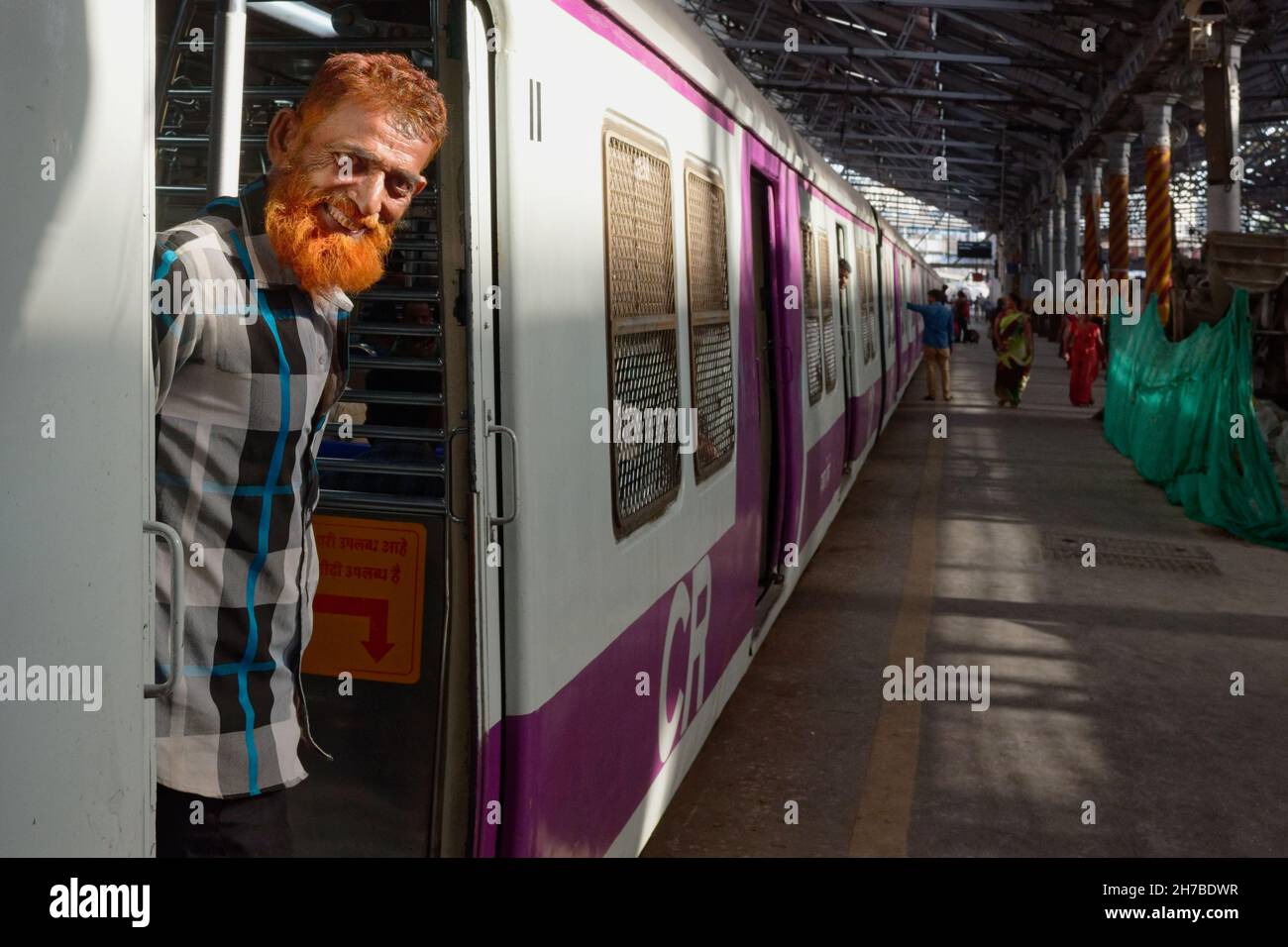 Un musulman avec une barbe de couleur henné se trouve à l'entrée d'un faux train de banlieue à Chhatrapati Shivaji Maharaj Terminus à Mumbai, en Inde Banque D'Images