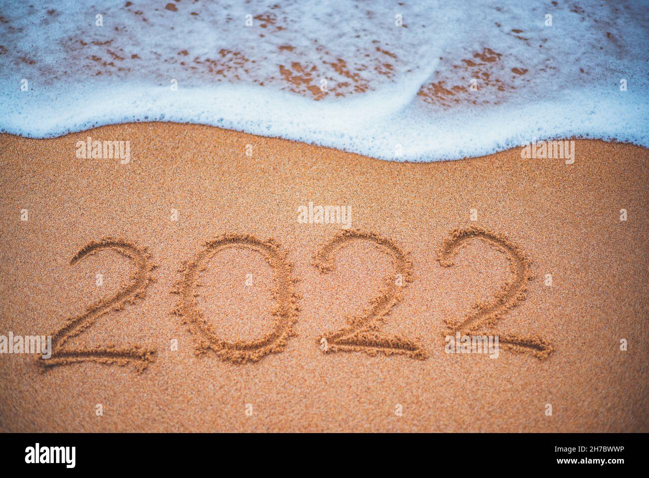 Concept du nouvel an 2022 heureux, lettrage sur la plage.Lever du soleil sur la mer. Banque D'Images